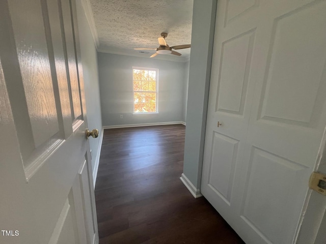 corridor with crown molding, a textured ceiling, and dark hardwood / wood-style floors