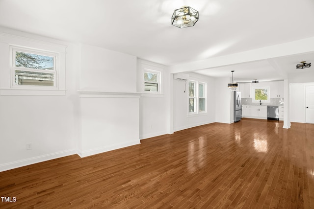 unfurnished living room with dark hardwood / wood-style flooring and sink