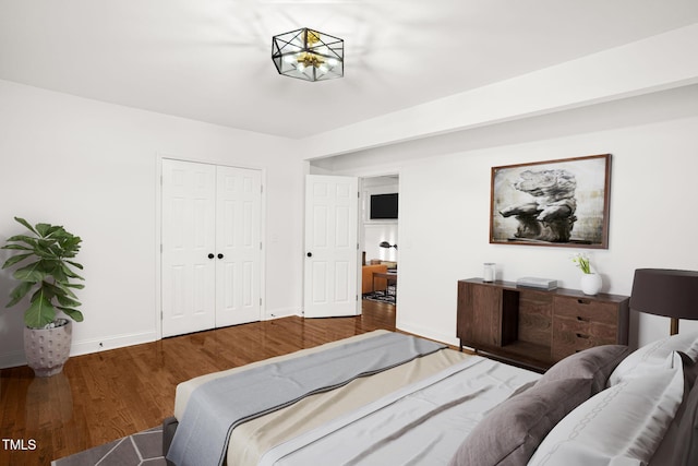 bedroom with dark hardwood / wood-style flooring and a closet