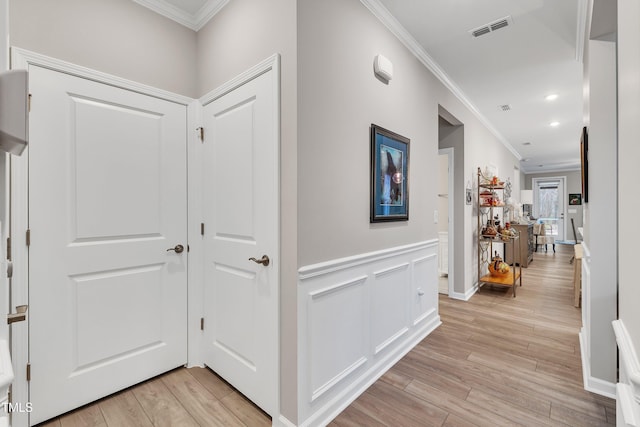 hallway with ornamental molding and light wood-type flooring