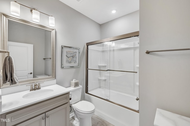 full bathroom featuring vanity, enclosed tub / shower combo, and toilet