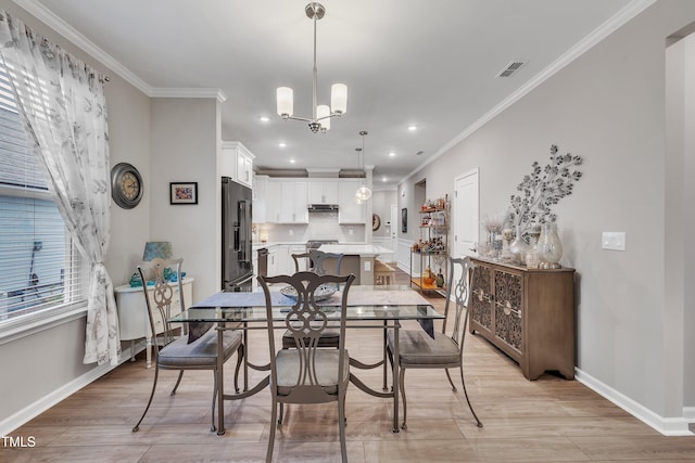 dining space with crown molding, a chandelier, and light hardwood / wood-style floors