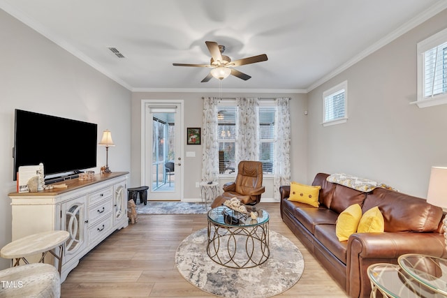 living room with crown molding, ceiling fan, and light wood-type flooring