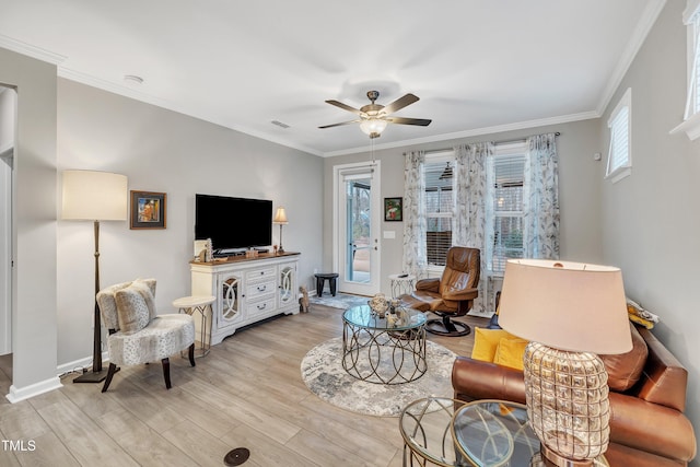 living room featuring crown molding, ceiling fan, and light wood-type flooring