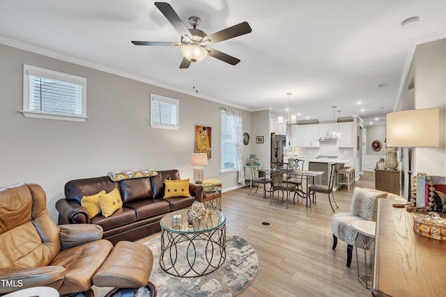 living room with ceiling fan, ornamental molding, and light hardwood / wood-style floors