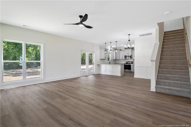 4935 High Branch Ct, Stedman, NC 28391 - unfurnished living room featuring stairway, a sink, dark wood-style floors, and ceiling fan with notable chandelier