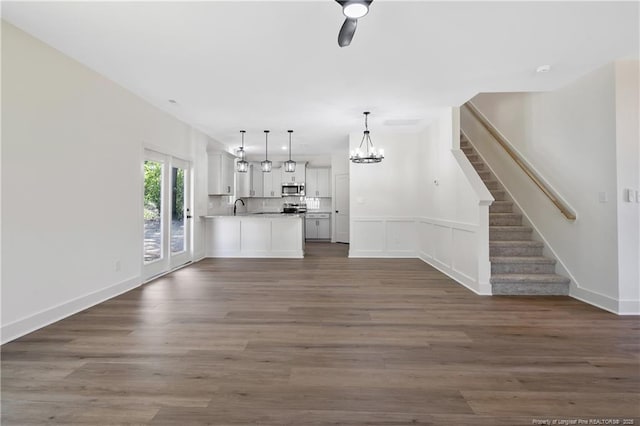 4935 High Branch Ct, Stedman, NC 28391 - unfurnished living room with dark wood-style flooring, stairs, a sink, and ceiling fan with notable chandelier