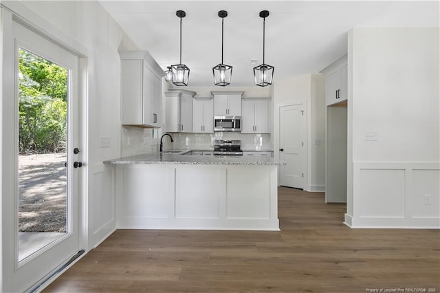 4935 High Branch Ct, Stedman, NC 28391 - kitchen with a sink, a peninsula, tasteful backsplash, light stone countertops, and appliances with stainless steel finishes