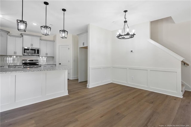4935 High Branch Ct, Stedman, NC 28391 - kitchen featuring tasteful backsplash, wood finished floors, light stone counters, a chandelier, and appliances with stainless steel finishes