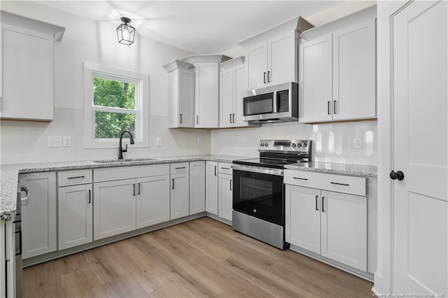 4935 High Branch Ct, Stedman, NC 28391 - kitchen featuring a sink, stainless steel appliances, light wood-type flooring, light stone countertops, and backsplash