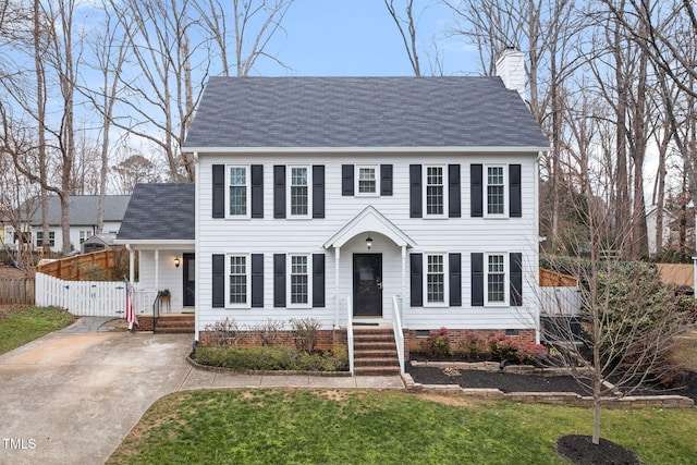 colonial-style house featuring a front lawn