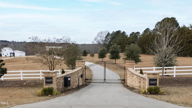 view of gate with a rural view