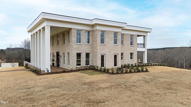 view of front of property with a balcony and a front yard