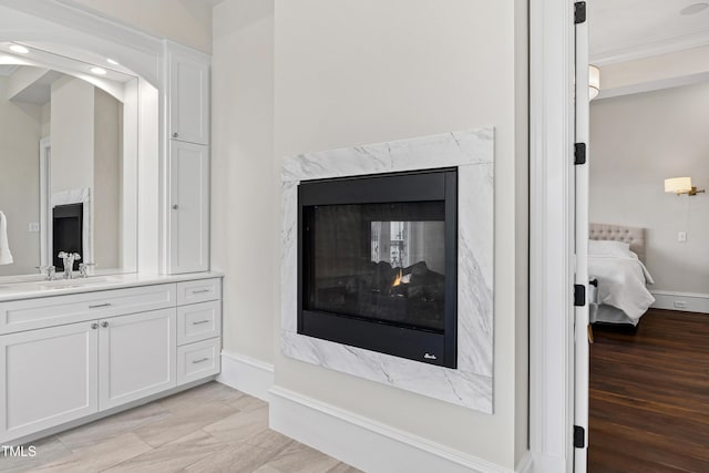 interior details with crown molding, sink, and a high end fireplace