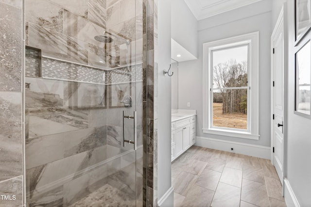 bathroom with vanity, crown molding, a shower with door, and a healthy amount of sunlight