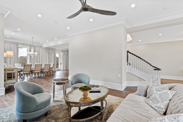 living room featuring crown molding, ceiling fan with notable chandelier, and hardwood / wood-style floors