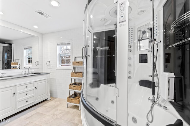 bathroom with tile patterned floors, vanity, separate shower and tub, and tile walls