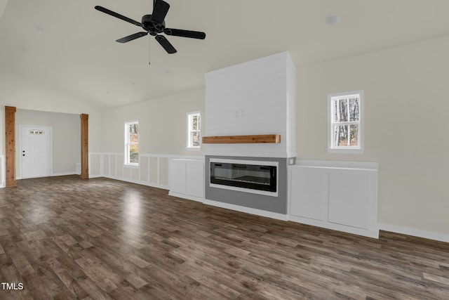 unfurnished living room with a fireplace, a healthy amount of sunlight, lofted ceiling, and dark hardwood / wood-style flooring