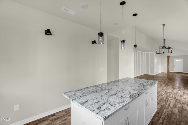 kitchen featuring pendant lighting, dark hardwood / wood-style flooring, white cabinetry, light stone countertops, and a kitchen island