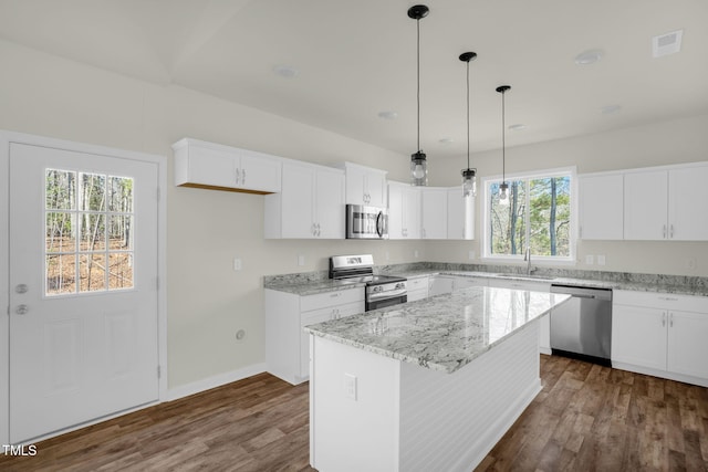 kitchen with white cabinets, a center island, a healthy amount of sunlight, and stainless steel appliances