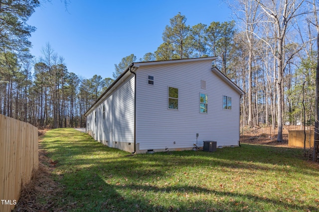 view of side of property with a lawn and central air condition unit