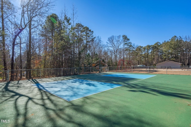 view of tennis court featuring a playground