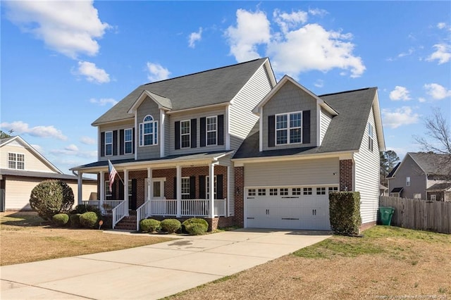 view of front of property with covered porch, a garage, and a front yard