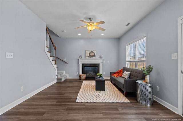 living room featuring ceiling fan and dark hardwood / wood-style floors