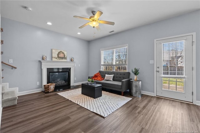 living room with dark hardwood / wood-style flooring and ceiling fan