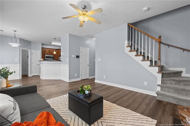 living room with dark wood-type flooring and ceiling fan