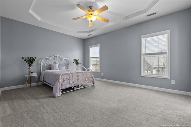 bedroom featuring a tray ceiling, carpet flooring, and ceiling fan