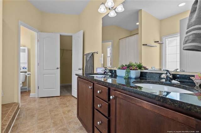 bathroom with toilet, vanity, and curtained shower