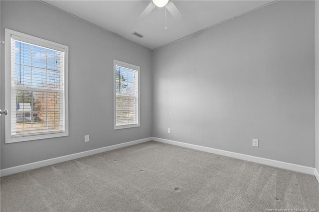 empty room featuring ceiling fan and carpet