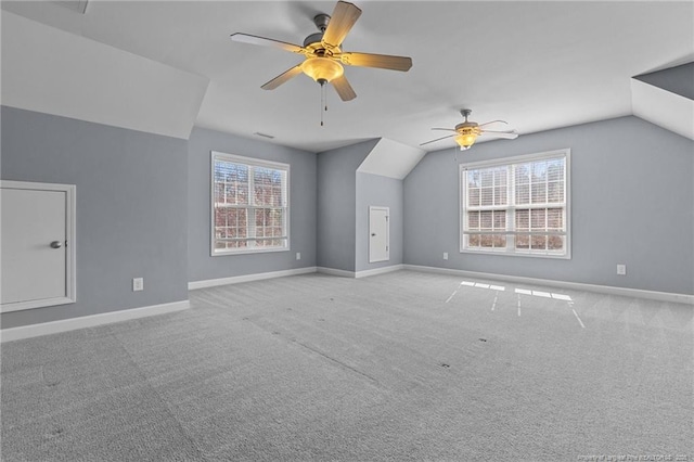 additional living space with ceiling fan, light carpet, vaulted ceiling, and a healthy amount of sunlight