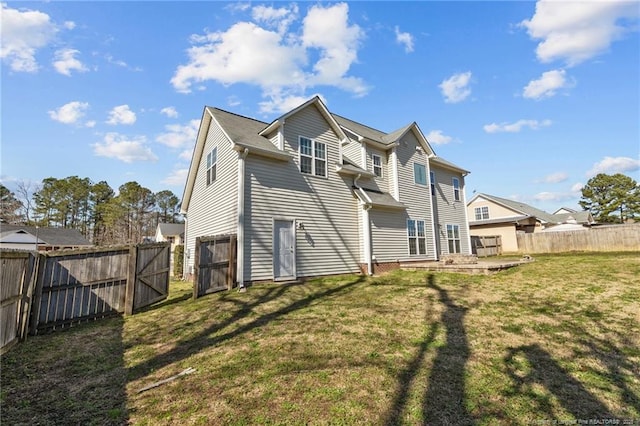 rear view of house featuring a yard