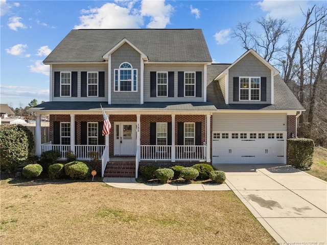 colonial home featuring brick siding, covered porch, driveway, and a front lawn