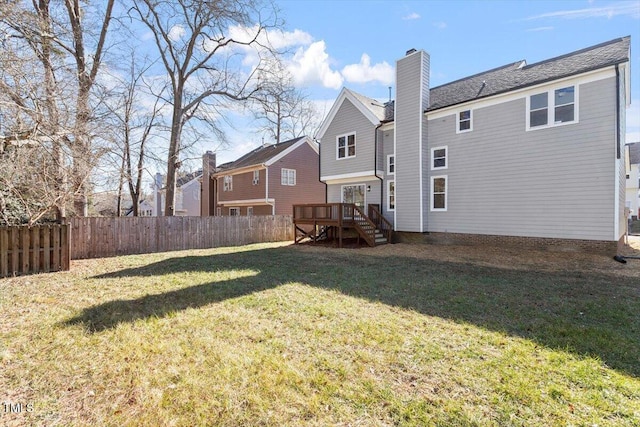 back of property featuring a lawn and a deck