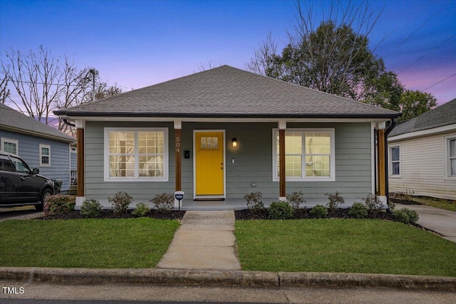 bungalow-style home with a porch and a yard