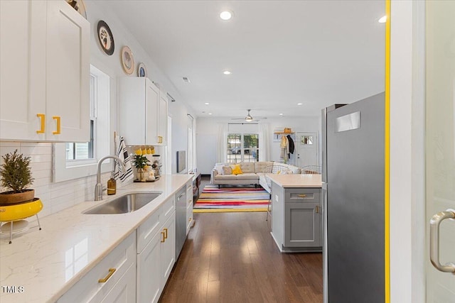 kitchen featuring tasteful backsplash, sink, a healthy amount of sunlight, and white cabinets