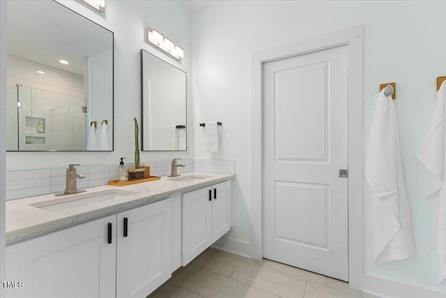 bathroom featuring tasteful backsplash, vanity, and a shower with shower door