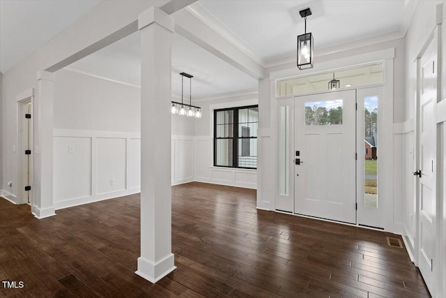 entryway with decorative columns, crown molding, and dark hardwood / wood-style flooring