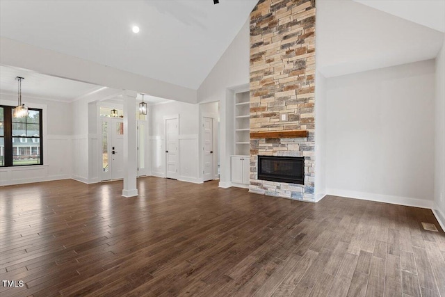 unfurnished living room with dark hardwood / wood-style flooring, built in shelves, a fireplace, and high vaulted ceiling