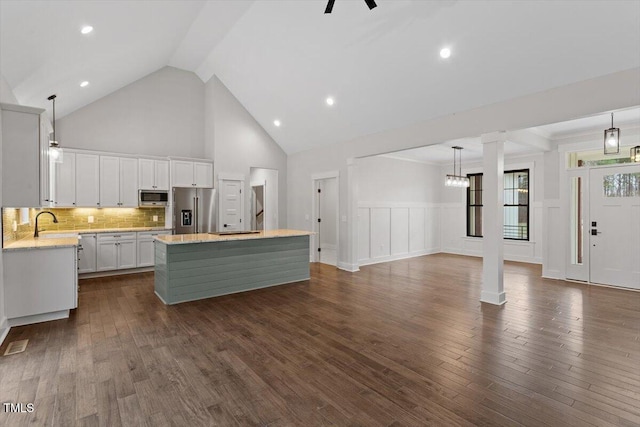 kitchen featuring a kitchen island, dark hardwood / wood-style floors, white cabinets, hanging light fixtures, and stainless steel appliances