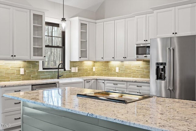 kitchen with pendant lighting, appliances with stainless steel finishes, tasteful backsplash, and white cabinets