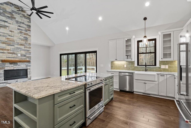 kitchen with pendant lighting, green cabinets, appliances with stainless steel finishes, white cabinets, and a kitchen island