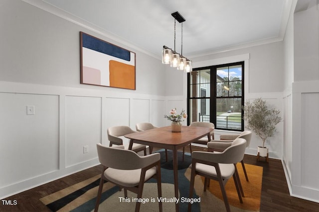 dining space featuring dark wood-type flooring, crown molding, and a chandelier