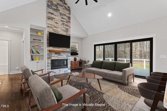 living room featuring a fireplace, wood-type flooring, built in features, and high vaulted ceiling