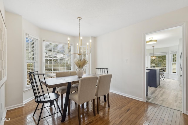 dining area with a notable chandelier and dark hardwood / wood-style floors