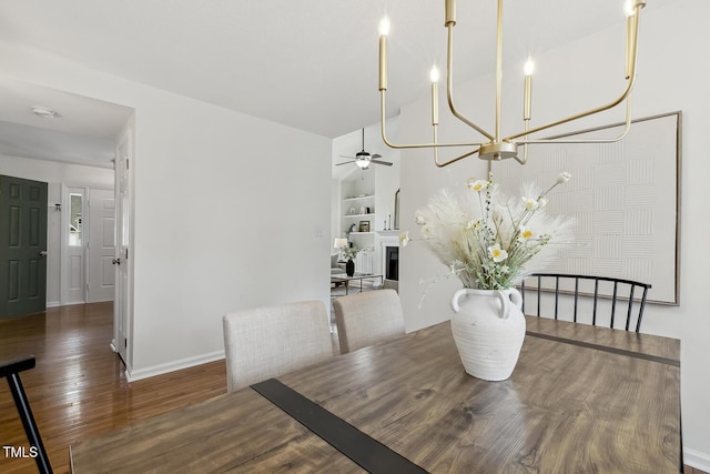 dining space with dark hardwood / wood-style flooring, built in shelves, and ceiling fan