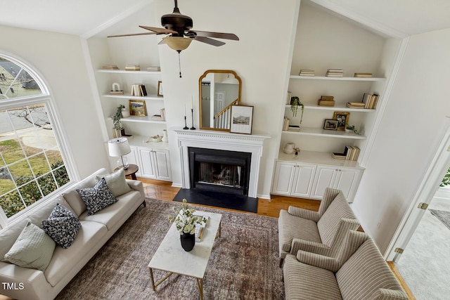 living room featuring built in shelves and ceiling fan